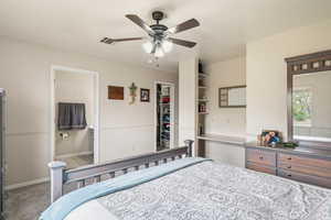 Bedroom with carpet floors, ceiling fan, and a spacious closet