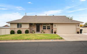 Ranch-style house with brick siding, a shingled roof, driveway, and an attached garage