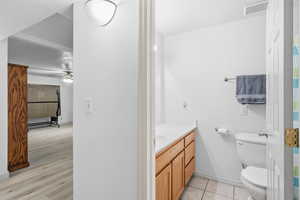 Bathroom featuring vanity, a textured ceiling, a shower with curtain, light tile patterned floors, and a ceiling fan