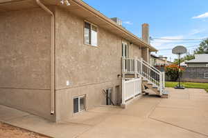 View of side of property with stucco siding and a patio