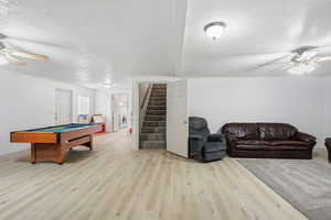 Game room featuring a ceiling fan, a textured ceiling, pool table, light wood finished floors, and crown molding
