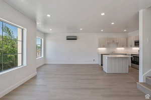 Kitchen with recessed lighting, a center island, light wood finished floors, stainless steel appliances, and open floor plan