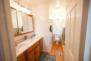 Master full bath featuring double vanity, light wood-type flooring, and a stall shower