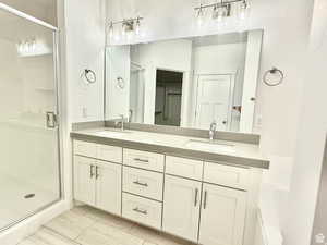 Bathroom with double vanity and a stall shower