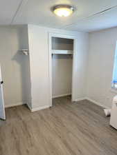Unfurnished bedroom with light wood-style flooring, a textured ceiling, and a closet