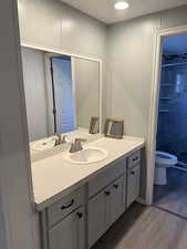 Bathroom featuring light wood-type flooring, vanity, a textured ceiling, recessed lighting, and a tile shower