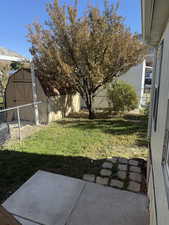 Fenced backyard featuring a storage shed and a patio