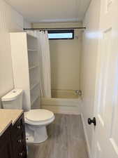 Full bathroom with shower / tub combo with curtain, light wood-style flooring, and vanity