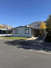 Manufactured / mobile home featuring a mountain view, driveway, and a carport