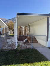 View of side of home with a fenced front yard, a gate, a mountain view, and an attached carport