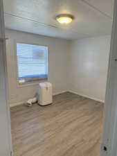 Empty room featuring a textured ceiling and light wood-style floors