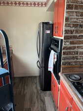 Kitchen featuring dark wood-style flooring and black appliances