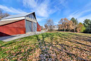View of yard with an outbuilding and a barn