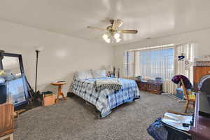 Bedroom featuring carpet, a textured ceiling, and ceiling fan