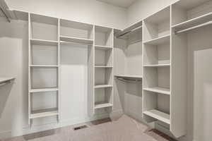 Walk in closet with light carpet