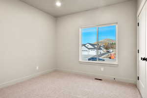 Carpeted empty room with recessed lighting and a residential view