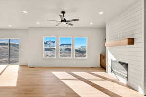 Unfurnished living room with a fireplace, recessed lighting, light wood finished floors, and a ceiling fan