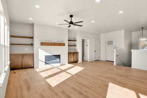 Unfurnished living room with light wood-style flooring, recessed lighting, a fireplace, and ceiling fan