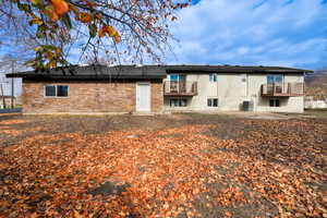 Back of house with a patio area and brick siding