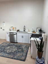 Laundry area with light wood-style floors and baseboards