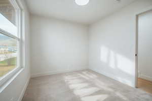 Empty room featuring light carpet and baseboards