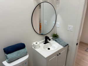 Half bath featuring vanity and light wood-type flooring
