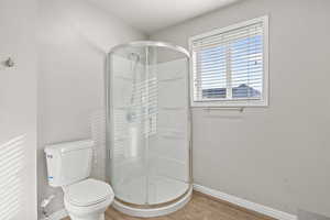 Bathroom featuring wood finished floors and a stall shower