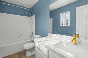 Bathroom with bathtub / shower combination, dark wood finished floors, and vanity