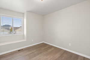 Unfurnished room with wood finished floors and baseboards