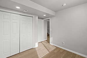 Unfurnished bedroom with light wood-style floors, recessed lighting, and a closet