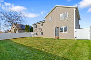 Back of house with a gate, entry steps, and a fenced backyard