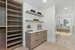 Walk in closet with light wood-style flooring