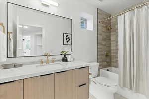 Bathroom with shower / bath combination with curtain and vanity