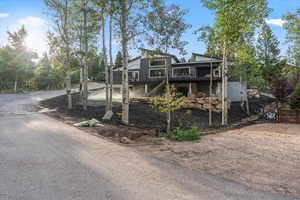 View of front facade featuring stairway and a deck