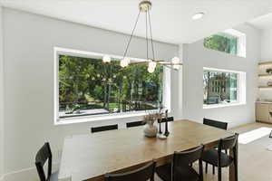 Tiled dining area with recessed lighting and baseboards