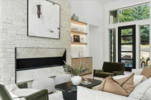 Living area featuring a fireplace, wood finished floors, and a high ceiling
