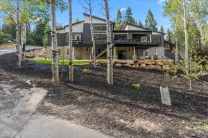 Back of property with stairs and a deck