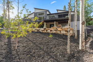 Rear view of property with stairs and a deck