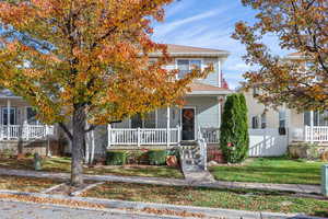 View of front of home featuring covered porch and a shingled roof