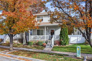 View of front of house with covered porch and a shingled roof