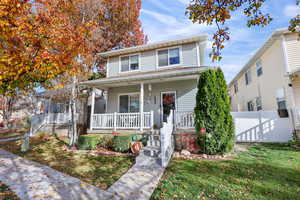 View of front of house with covered porch and a front lawn