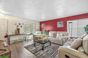 Living area featuring a textured ceiling and wood finished floors