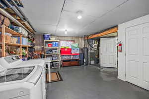 Unfinished below grade area with washer and dryer, heating unit, and water heater