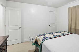 Bedroom with light carpet and a textured ceiling