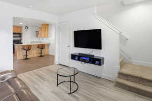 Living room featuring stairway, light wood finished floors, and recessed lighting