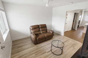 Sitting room with light wood-style floors and ceiling fan