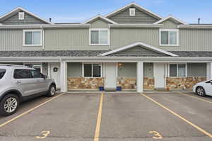 View of front of house with uncovered parking, roof with shingles, and board and batten siding