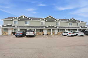 View of front of home featuring stone siding and uncovered parking