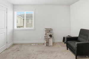 Sitting room featuring light carpet and baseboards