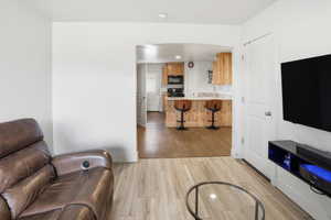 Living room featuring light wood finished floors, recessed lighting, and arched walkways
